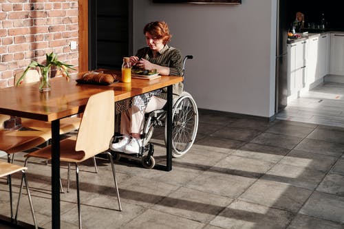 Stay safe: Coronavirus guide Woman in a wheelchair eating alone at table